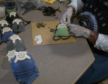 A worker wearing protective gloves attaches an elastic strap to a silicone face mask at Mask & Shield, a division of Monster City Studios, in Fresno, California, U.S., on Wednesday, May 27, 2020. Monster City Studios, a company that normally makes amusement park and movie props, has pivoted to manufacturing MCS face shields with forehead protection. Photographer: David Paul Morris/Bloomberg via Getty Images