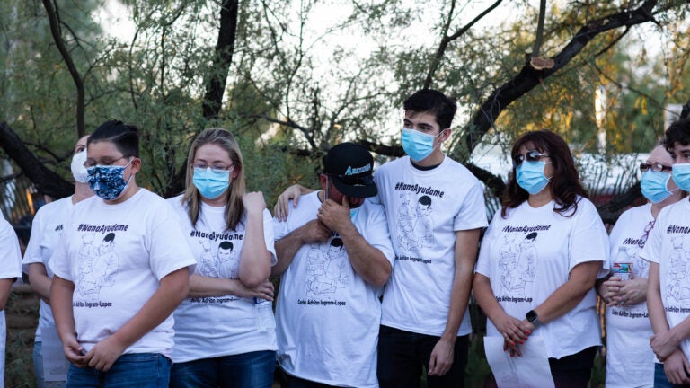 Community members and family wear shirts that read 