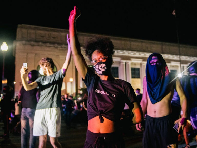 Demonstrators raise their fist in the air, in front of law enforcement, on August 25, 2020 in Kenosha, Wisconsin. As the city declared a state of emergency curfew, a third night of civil unrest occurred after the shooting of Jacob Blake, 29, on August 23. Video shot of the incident appears to show Blake shot multiple times in the back by Wisconsin police officers while attempting to enter the drivers side of a vehicle. The 29-year-old Blake was undergoing surgery for a severed spinal cord, shattered vertebrae and severe damage to organs, according to the family attorneys in published accounts. (Photo by Brandon Bell/Getty Images)