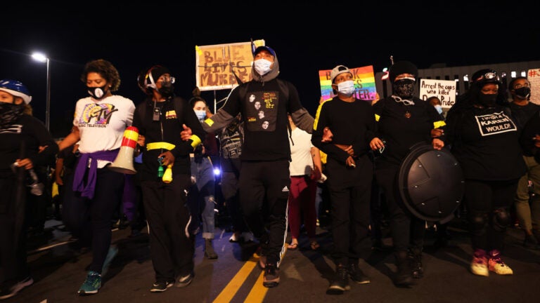 Demonstrators lock arms as they march for Daniel Prude on Friday in Rochester, N.Y. Prude died after being arrested on March 23 by Rochester police officers, who had placed a 