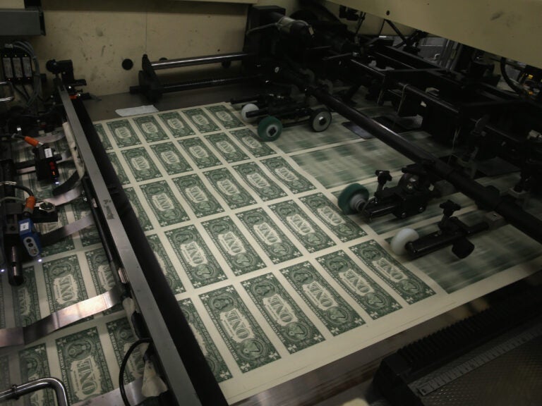 Sheets of $1 bills run through the printing press in 2015 at the U.S. Bureau of Engraving and Printing in Washington, D.C. National debt is expected to reach an all-time high of 107% of gross domestic product in 2023.