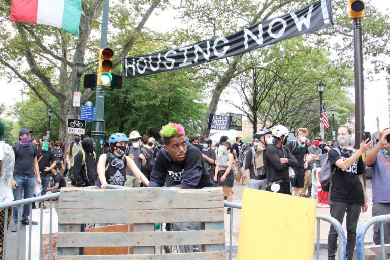 Protesters wait behind blockades to defend the Parkway homeless encampment