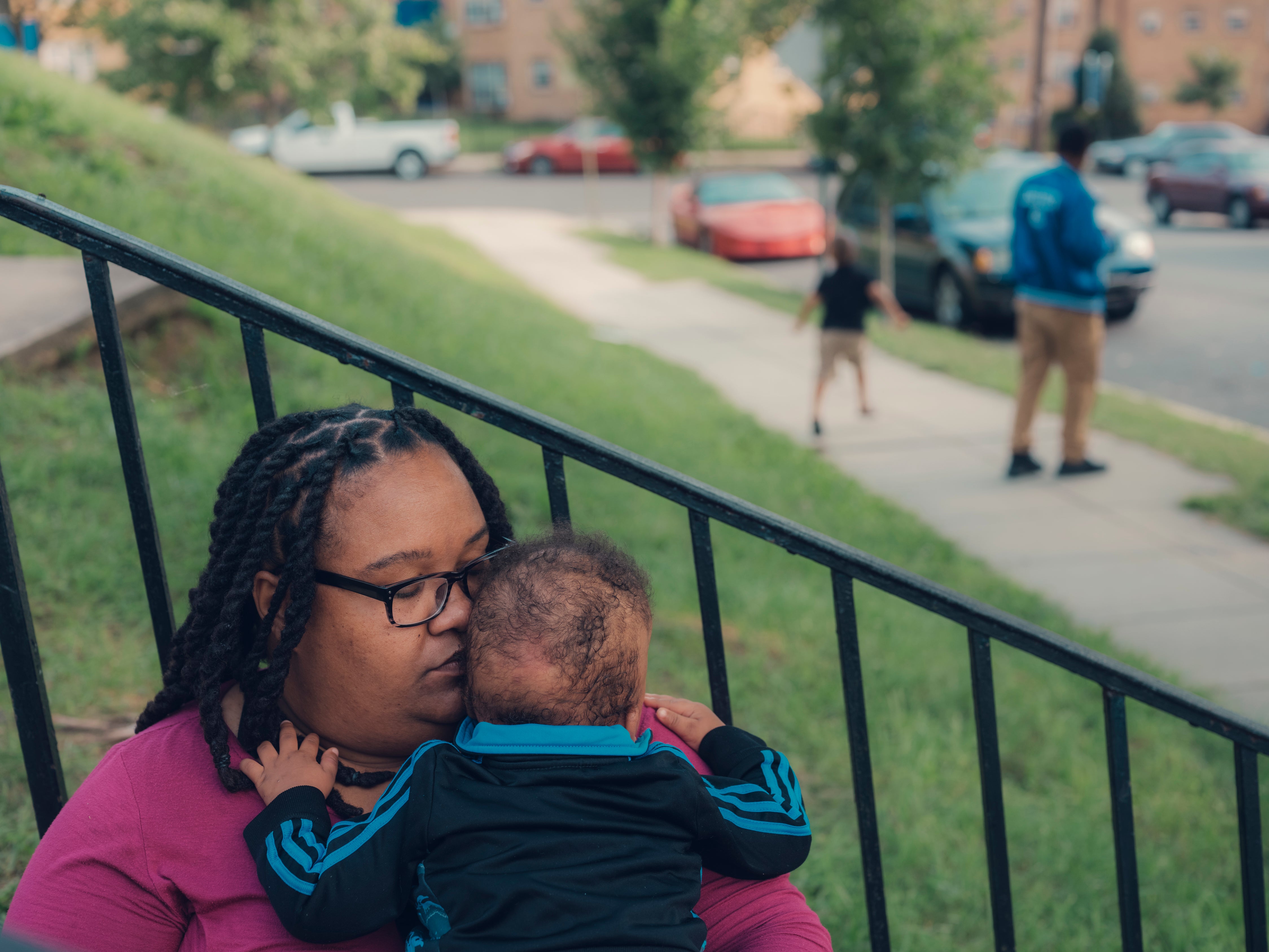 Patricia Stamper holds her younger son, 1, at their home