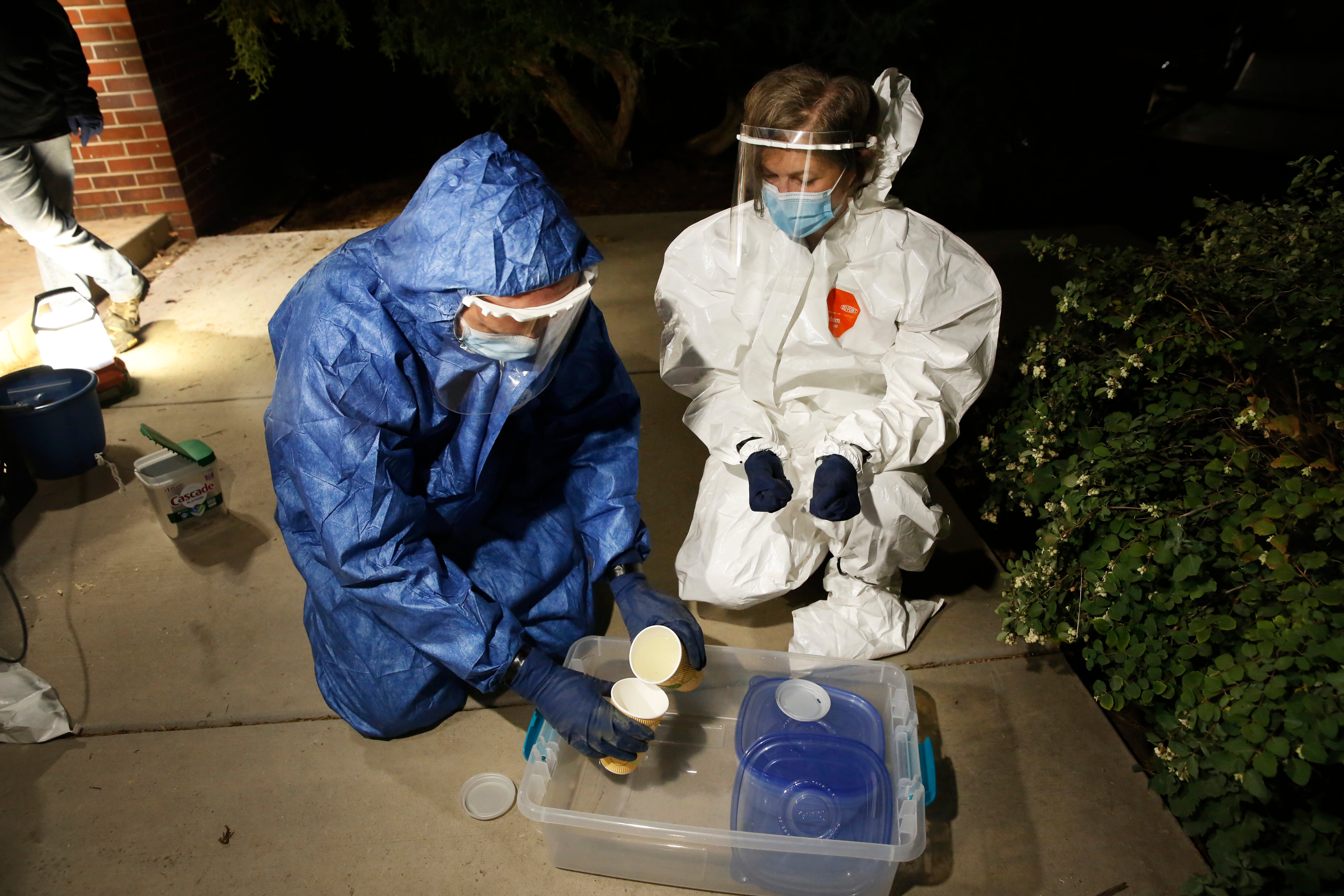 Bruder (right) and her colleague, environmental science professor Miroslav Kummel, pour wastewater samples from to-go coffee cups outside South Hall