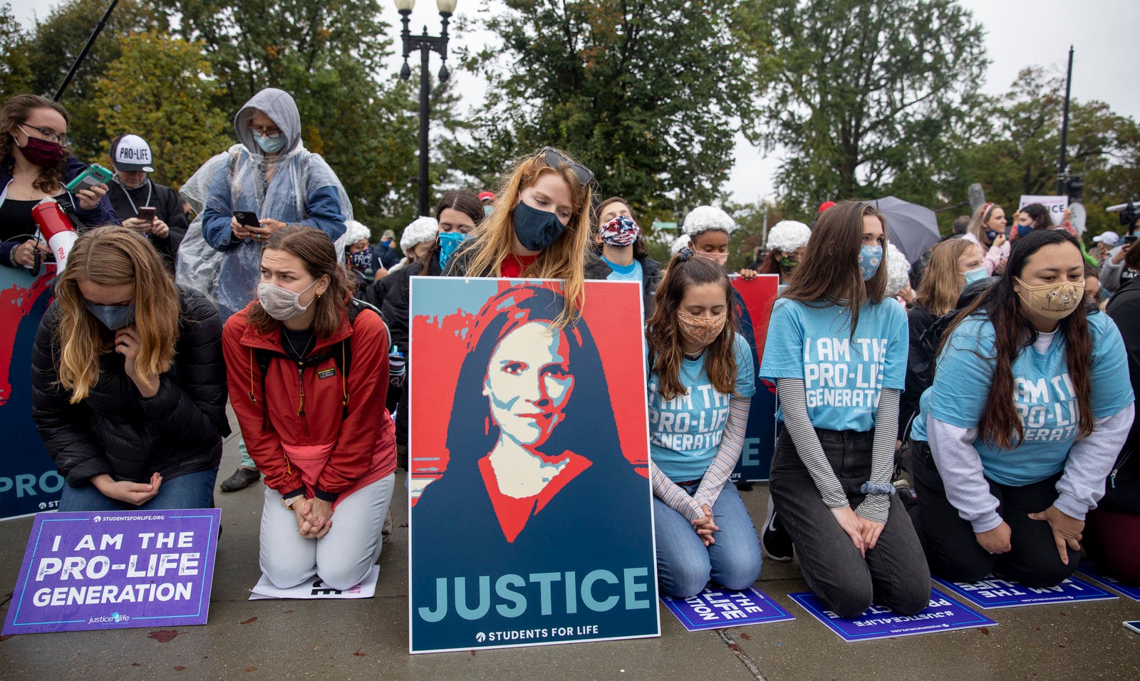 Anti-abortion rights protesters kneel in prayer in front of the Supreme Court Monday in support of President Trump's nominee to the court, Amy Coney Barrett