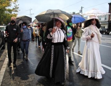 Jeannine Cook (right) owner of Harriett's Bookshop in Fishtown, and her sister Jasmaine Cook, lead a procession on East Girard Avenue