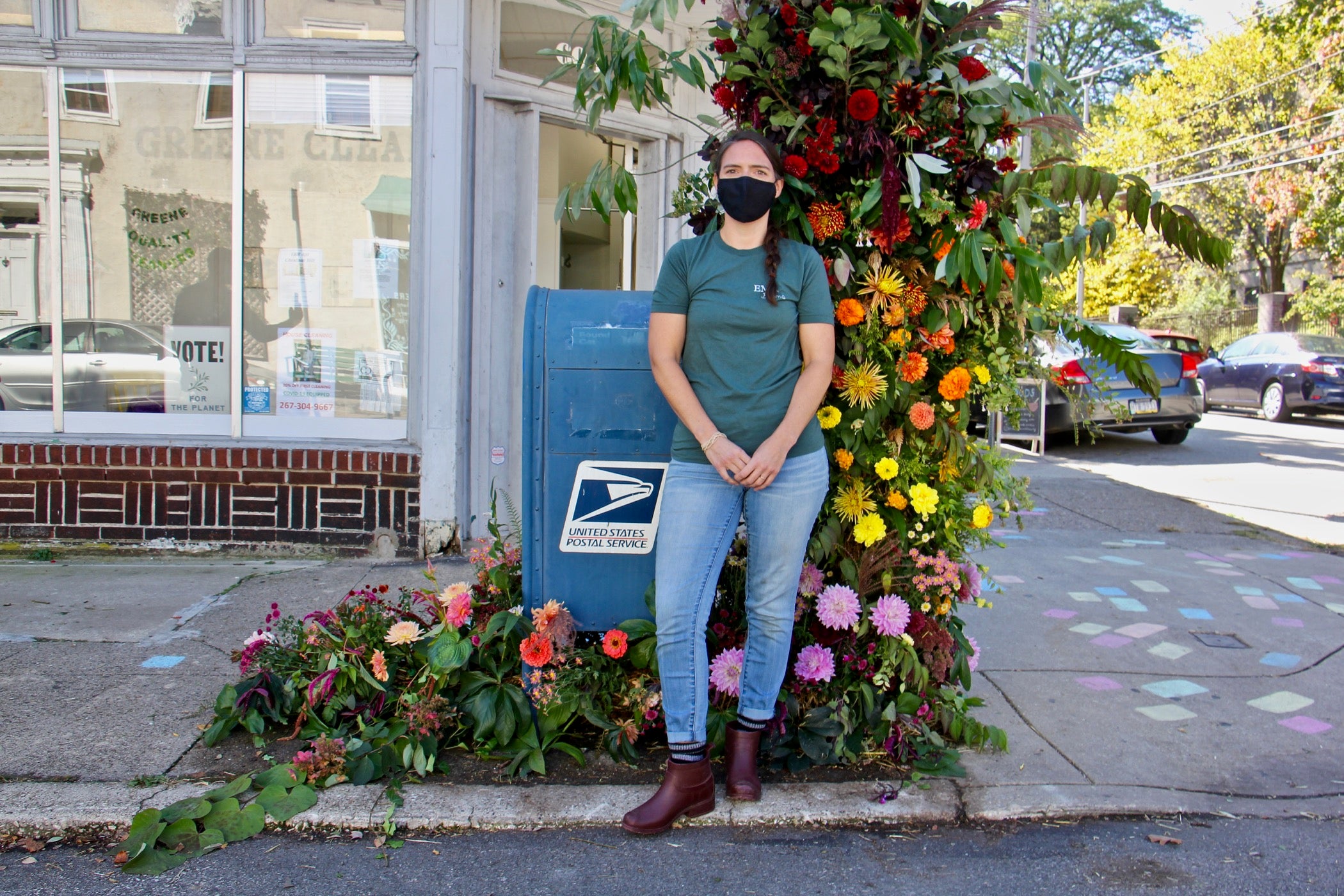 Florist Kate Carpenter stands my her floral arrangement by a mailbox.