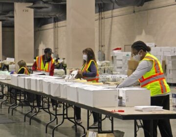 Workers at the Pennsylvania Convention Center prepare election boxes that will go out to polling places on Election Day. (Emma Lee/WHYY)