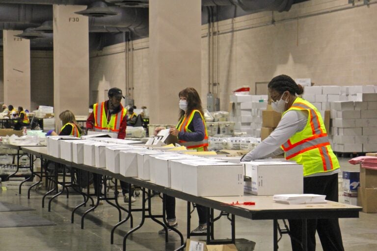 Workers at the Pennsylvania Convention Center prepare election boxes that will go out to polling places on Election Day. (Emma Lee/WHYY)