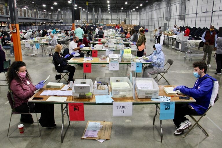 Camden County election workers, paired by party, open and inspect mail ballots at Camden County Elections and Archive Center