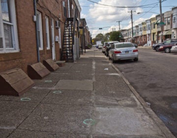 Chalk circles drawn on the sidewalk mark where shell casings landed at 22nd and Jackson Streets in South Philadelphia. (Kimberly Paynter/WHYY)