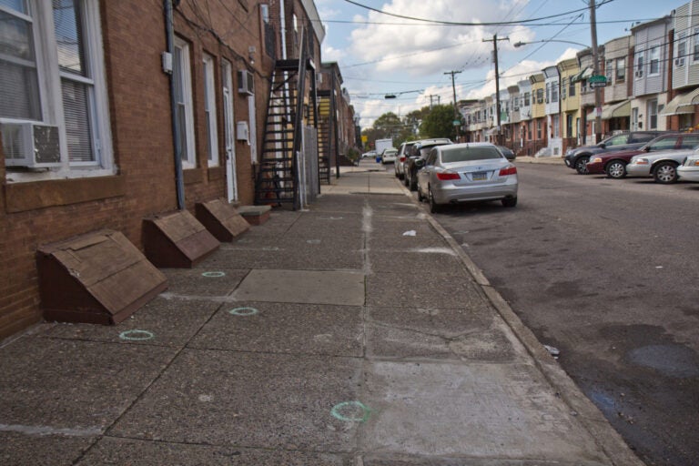 Chalk circles drawn on the sidewalk mark where shell casings landed at 22nd and Jackson Streets in South Philadelphia. (Kimberly Paynter/WHYY)