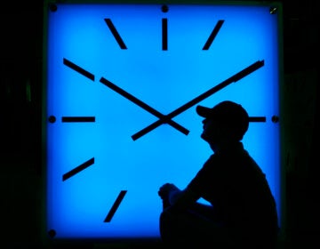 In this Oct. 30, 2008, file photo, Electric Time Company employee Dan Lamoore adjusts the color on a 67-inch square LED color-changing clock at the plant in Medfield, Mass. (AP Photo/Elise Amendola)