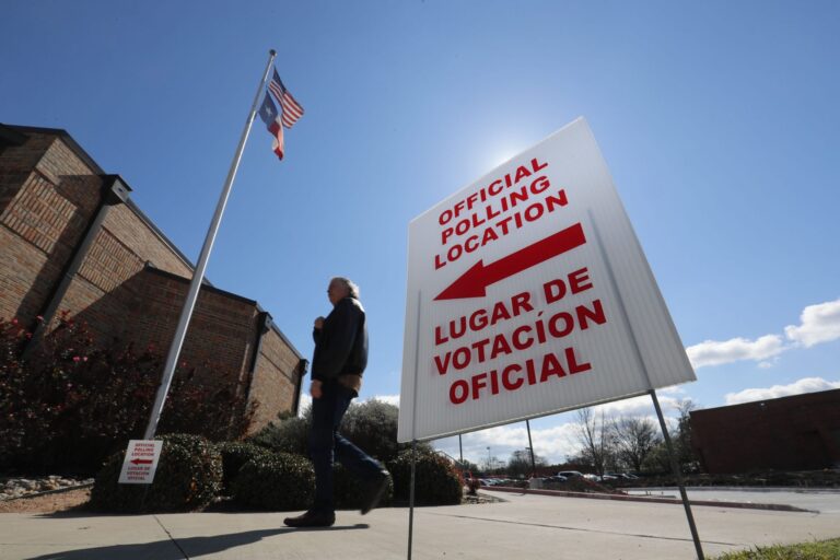 In this Feb. 26, 2020 file photo, using both the English and Spanish language, a sign points potential voters to an official polling location during early voting in Dallas. (LM Otero/AP Photo)