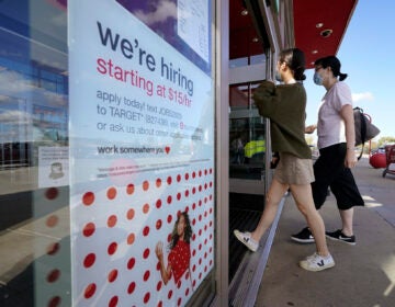 Passers-by walk past a hiring sign as they enter a Target retail store location, Wednesday, Sept. 30, 2020, in Westwood, Mass. (AP Photo/Steven Senne)