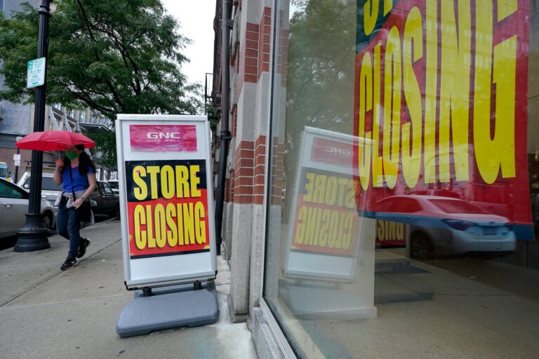 In this Sept. 2, 2020, file photo, a passerby walks past a business storefront with store closing signs in Boston. (AP Photo/Steven Senne)