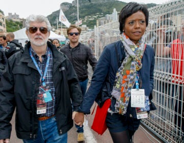 Mellody Hobson, right, walks with film director George Lucas after the qualifying session at the Monaco racetrack in Monaco, Saturday, May 25, 2013. (AP Photo/Claude Paris)