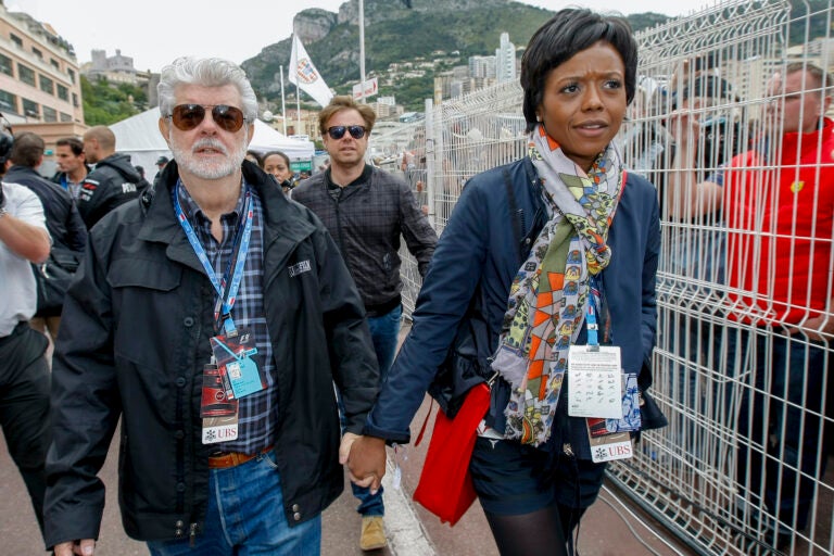 Mellody Hobson, right, walks with film director George Lucas after the qualifying session at the Monaco racetrack in Monaco, Saturday, May 25, 2013. (AP Photo/Claude Paris)