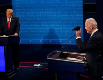 Democratic presidential candidate former Vice President Joe Biden holds up a mask as President Donald Trump takes notes during the second and final presidential debate Thursday, Oct. 22, 2020, at Belmont University in Nashville, Tenn. (AP Photo/Morry Gash, Pool)