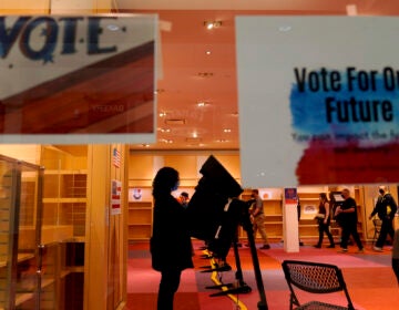 A woman casts her ballot on the first day of early voting in a recently-shuttered store at Oak Park Mall Saturday, Oct. 17, 2020, in Overland Park, Kan. (AP Photo/Charlie Riedel)