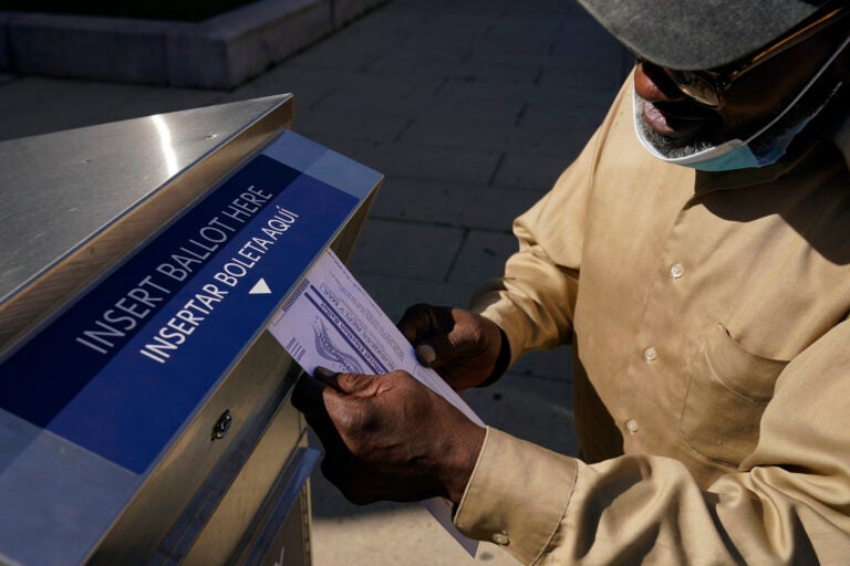 Robert Reed deposits his ballot in an election drop box in Newark, N.J.