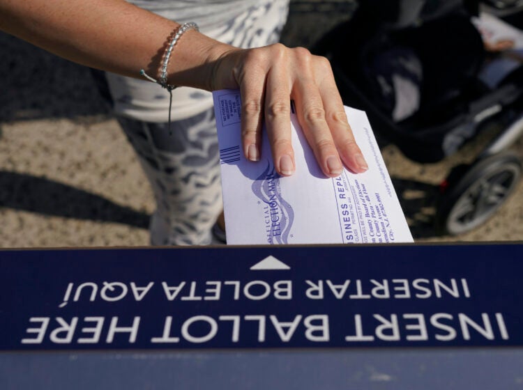 A woman deposits her ballot in an election drop box in Jersey City, N.J.