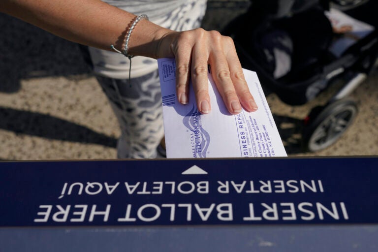 A woman deposits her ballot in an election drop box in Jersey City, N.J.