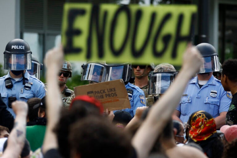 Protesters rally as Philadelphia Police officers and Pennsylvania National Guard soldiers look on in Philadelphia