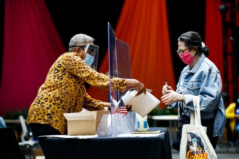 A voter checks in with an election worker before casting her ballot