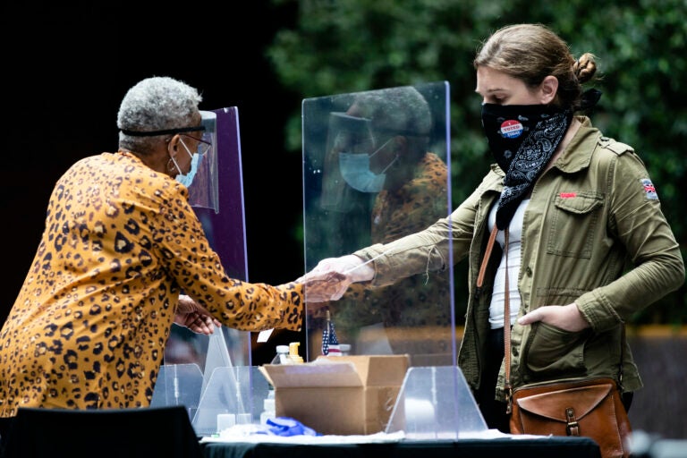 A voter checks in with an election worker before casting her ballot