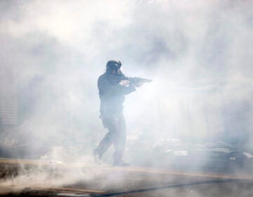 A police officer moves through tear gas deployed to disperse a crowd as Justice for George Floyd Philadelphia protests continue in Philly