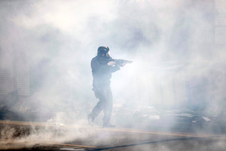 A police officer moves through tear gas deployed to disperse a crowd as Justice for George Floyd Philadelphia protests continue in Philly