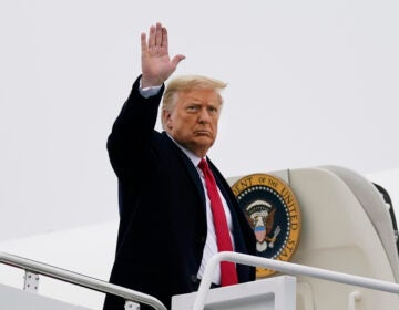 President Donald Trump waves as he boards Air Force One