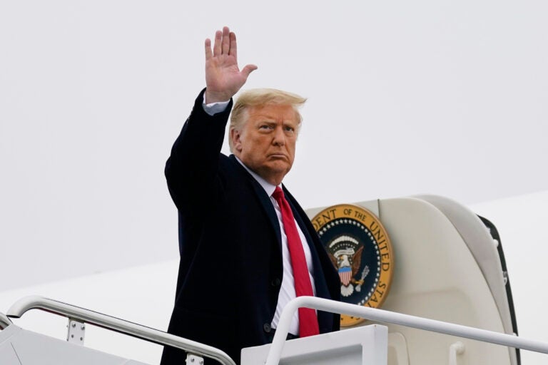 President Donald Trump waves as he boards Air Force One