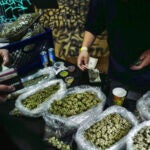 A vendor makes change for a marijuana customer at a cannabis marketplace