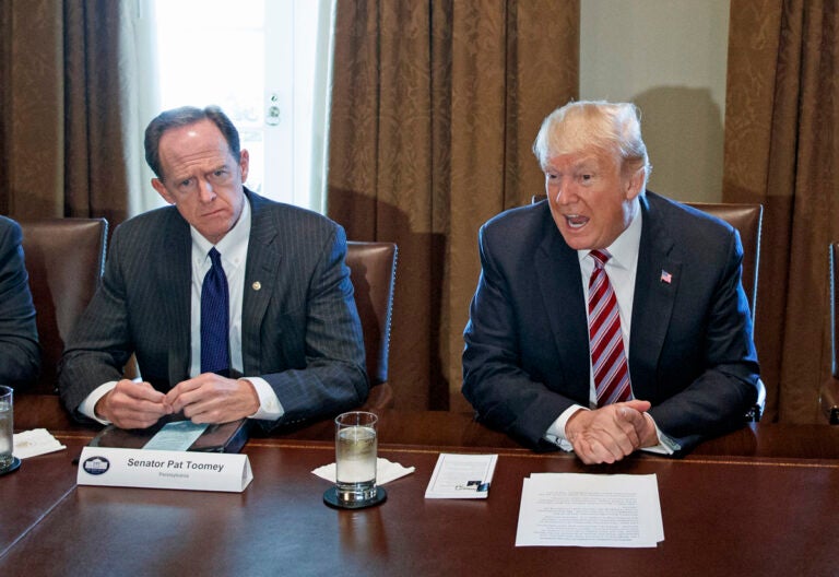 Sen. Pat Toomey (left) sits beside President Donald Trump during a meeting with lawmakers about trade policy in the Cabinet Room of the White House, Tuesday, Feb. 13, 2018, in Washington. (AP Photo/Evan Vucci)