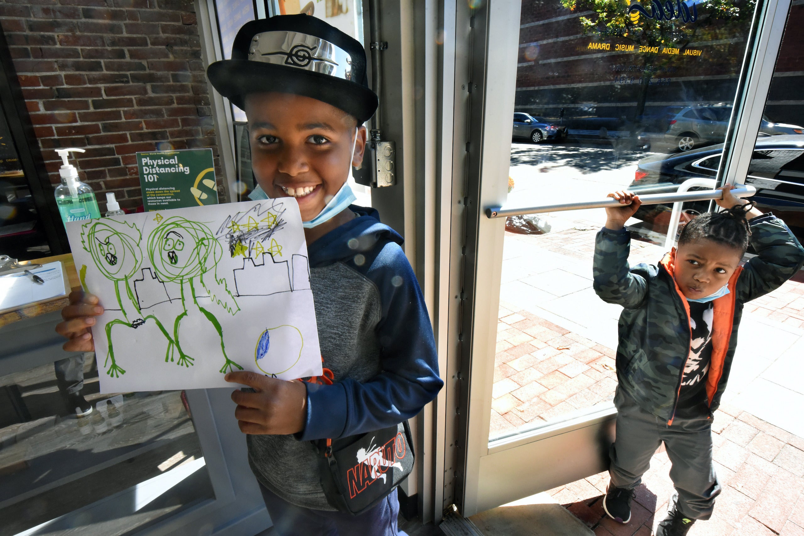 Efun Deji, 8, shows a drawing he made in his first art class