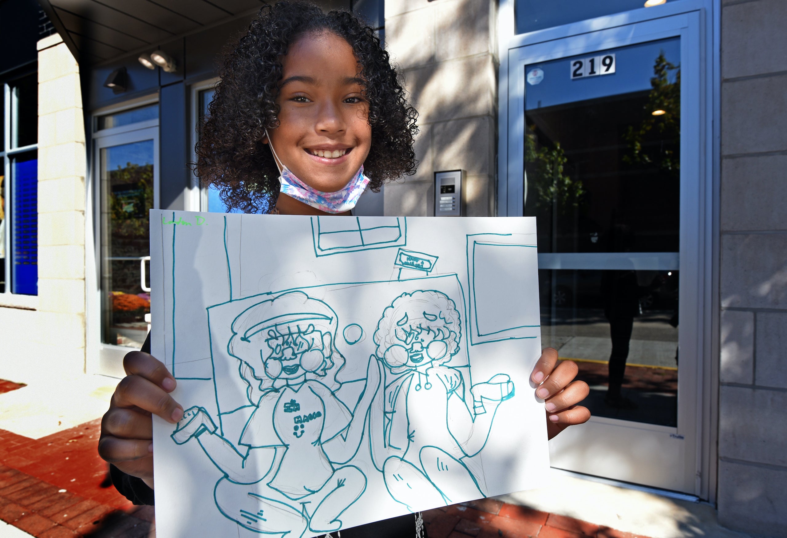 Art student London Daniels, 10, shows a drawing she made with the theme "togetherness."