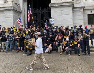 Passerby walks between the camera and the Proud Boys as they pose for a photo. (Courtesy of Jason Peters)