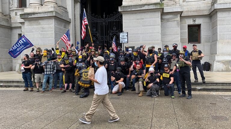 Passerby walks between the camera and the Proud Boys as they pose for a photo. (Courtesy of Jason Peters)