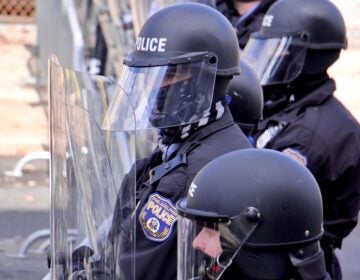 Police in riot gear meet protesters at 54th and Pine streets, barring their progress East on Pine Street. (Emma Lee/WHYY)