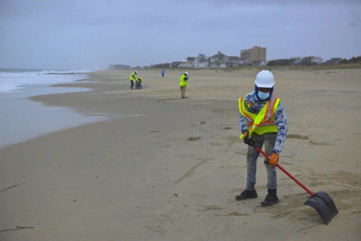 Workers help clean Delaware beach after oil spill