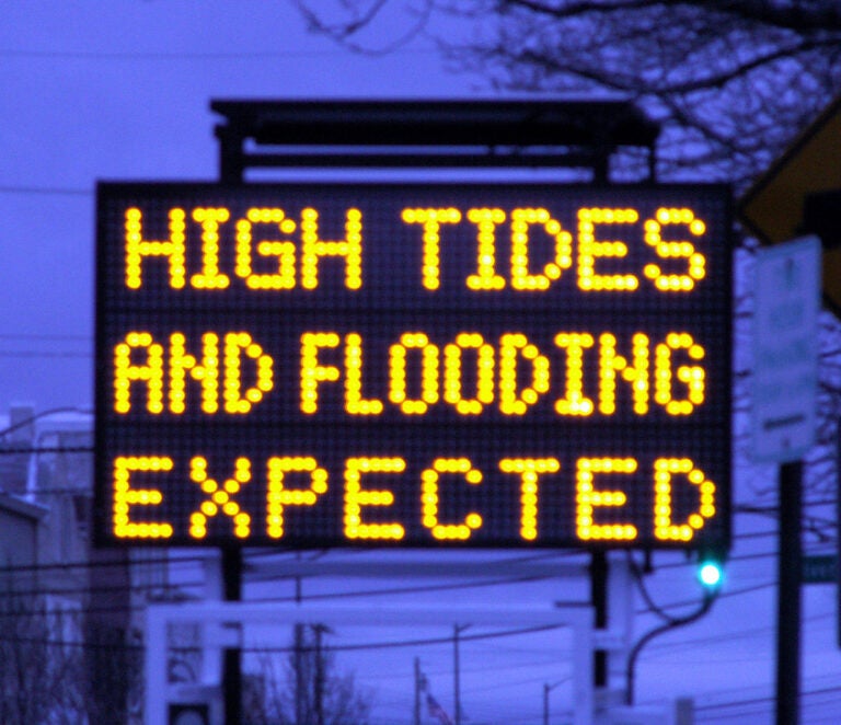 A road sign warns of high tides and expected flooding