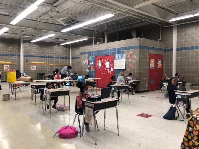 Students are socially distanced while attending class virtually at A list of rules is pictured at Vogt Access Center