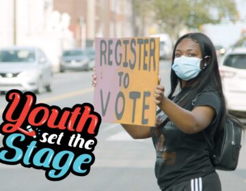 a young woman wearing a mask holds a sign that says REGISTER TO VOTE