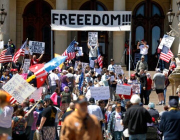 People protest at the state Capitol during a rally in Lansing, Mich.