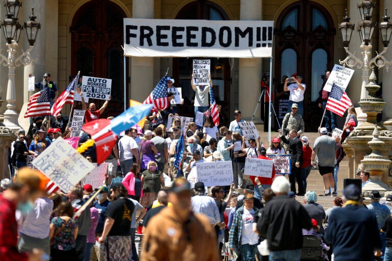 People protest at the state Capitol during a rally in Lansing, Mich.