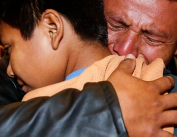 David Xol of Guatemala hugs his son Byron
