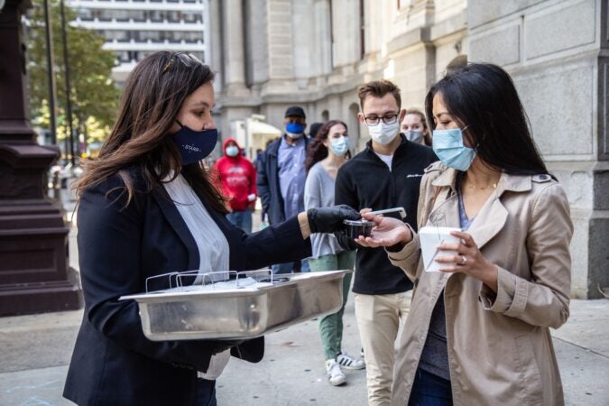 South Philadelphia resident Stevanie Rideout receives donuts and jam as she waits in line to vote, part of the “Fuel the Vote” effort.