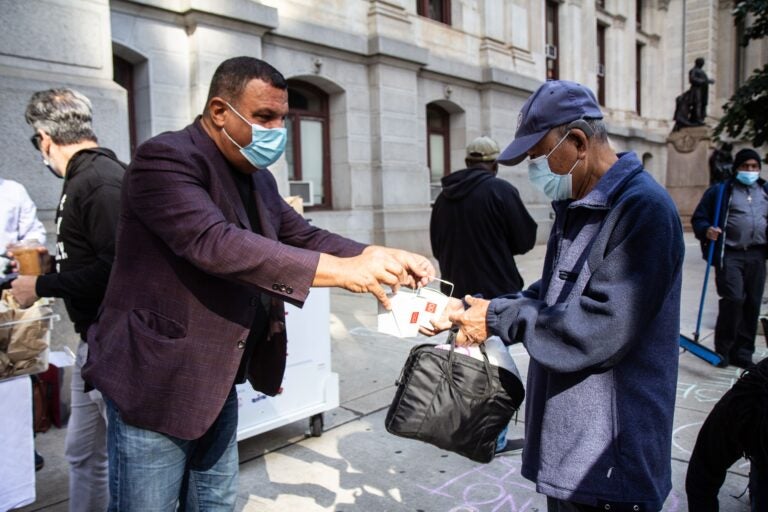 Stephen Starr (left) hands out food to voters as part of the “Fuel the Vote” effort